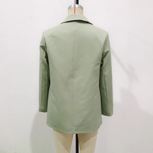 Detail view of light green women blazer jacket back seams on white background