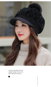 Close-up of a black winter knit hat with a large pompom and stylish front brim detail