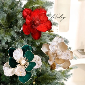Fleurs de Noël en velours rouge et champagne avec paillettes d'or sur un sapin de Noël