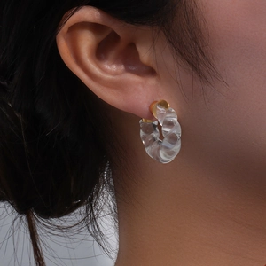 Boucles d'oreilles créoles torsadées en acrylique avec base dorée sur mannequin