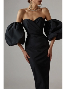 Detail of off-shoulder black party dress with voluminous puff sleeves and silky texture