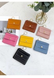 Flat lay of colorful PU leather key pouches with metal keychains on marble surface