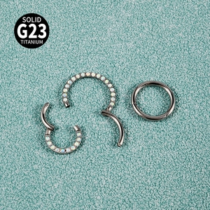 Macro detail of G23 titanium hinged ring with inlaid opal showing closure mechanism
