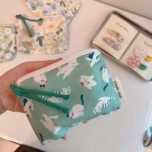 Detail of green cotton coin purse with cat print, zipper, and wrist strap detail