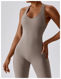 Close-up of moisture-wicking yoga jumpsuit showing taupe athletic fabric and seams
