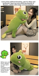 Macro detail of the soft green plush dinosaur pillow showing stitching and yellow back fins