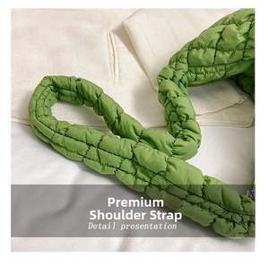 Macro detail of grass green quilted bubble strap showing soft padded texture and stitching