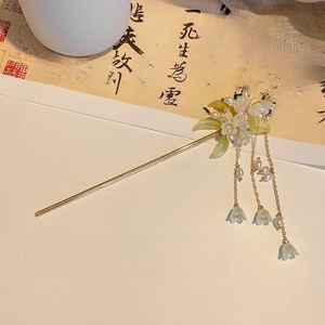 Detail shot of lily of the valley hair pin with golden tassels and pearls in oriental style