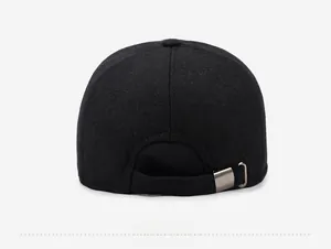 Detail view of the back of a black wool blend baseball cap with an adjustable metal strap