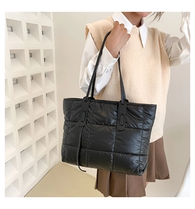 Chic quilted black space cotton tote bag worn by model over shoulder for large capacity view