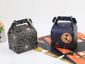 Detail of Halloween cake boxes showing spider web and witch patterns on flat and folded paper