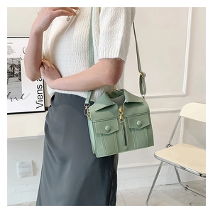 Model wearing the bean green jacket-shaped mini crossbody bag with gold zippers