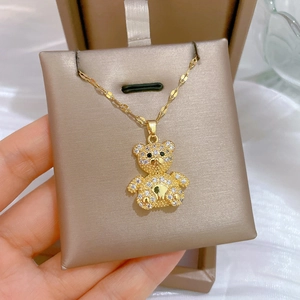 Detailed view of a gold teddy bear pendant encrusted with clear and black crystals