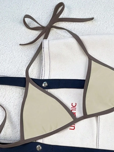 Detail view of a beige triangle bikini top with dark brown straps and metal hardware