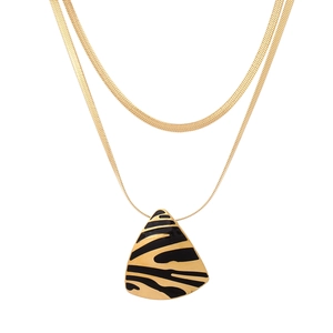 Détail du collier double rang en or avec pendentif triangle à motif zébré noir et doré