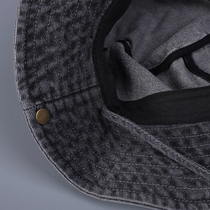 Detailed interior of washed denim sun hat featuring sweatband and metal snap button