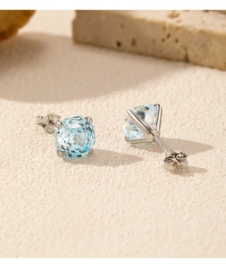 Macro shot of s925 silver stud earrings featuring light blue round cut aquamarine stones