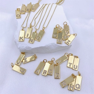 Detail view of 26 gold alphabet rectangular pendants with sparkling zircon stone setting