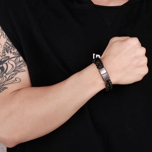 Close-up of men's vintage punk woven bracelet with antique metal clasp on wrist