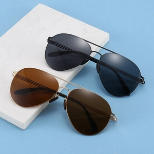 Close-up of black and gold pilot aviator sunglasses on white marble block base