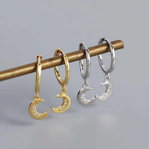Detail of gold and silver S925 moon hoop earrings with cubic zirconia pendant