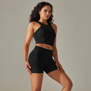 Detail of black seamless knitted two-piece yoga set with cropped vest and high-waist shorts