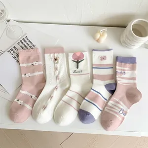 Detailed macro shot of cotton socks featuring embroidered tulips and soft pastel stripes