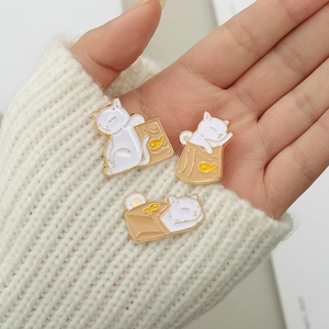 Three-piece set of cute cat and fish bag enamel lapel pins on a warm knitted sweater