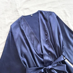 Women's dark blue satin silk robe with V-neck and tie waist belt on white fabric