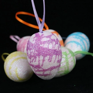 Macro detail of colorful glitter Easter egg ornaments with silk ribbons for festive hanging