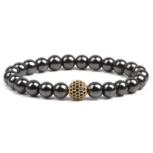 Detail of beaded hematite bracelet featuring a gold paved bead with black crystals