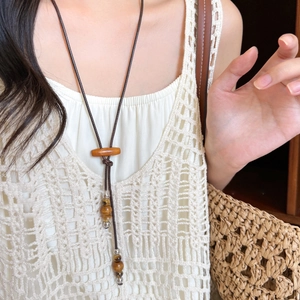 Collier bohème avec perles en céramique et bois et pendentif à franges et glands