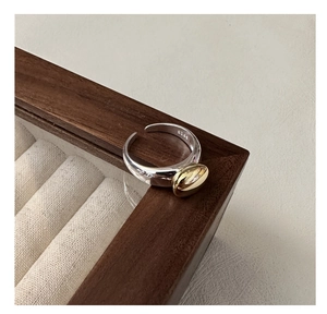 Detailed macro view of S925 sterling silver stamp on minimalist bicolor oval bean ring