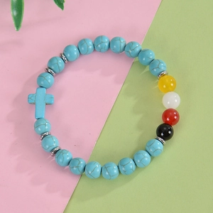Detail of blue turquoise beaded bracelet with cross charm and colorful accent beads
