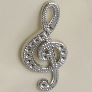 Macro shot of silver 304 stainless steel treble clef pendant with grainy metal texture