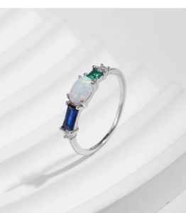 Detail of s925 silver ring featuring opal, blue and green gems on white texture