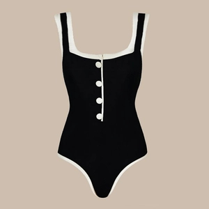 Dettaglio del costume intero nero con bordi bianchi a contrasto e bottoni decorativi