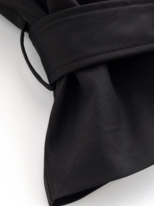 Gros plan détaillé de la texture du tissu sergé noir et des coutures sur le gilet