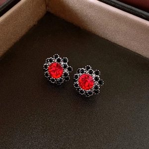 Macro shot of vintage round stud earrings with red and black crystal stones