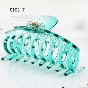 Detail of mint green resin hair claw clip with transparent texture and metal spring