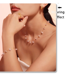 Model wearing a pink natural stone necklace and bracelet set with golden earrings