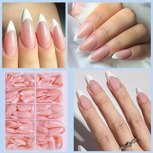 Almond French fake nails in nude pink and white tips stored in a clear organizer box