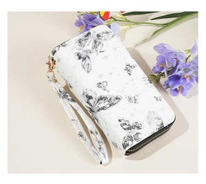 Detail of white PU leather wallet featuring black butterfly print and gold zipper finish