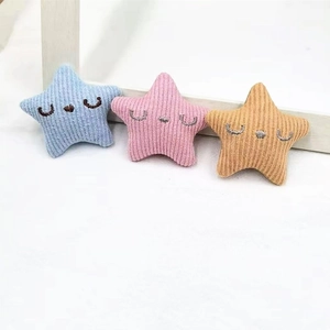 Close-up of pastel plush star pins with embroidery in blue, pink and yellow shades