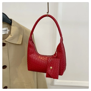 Detail of red woven texture shoulder bag with matching round coin purse on beige coat