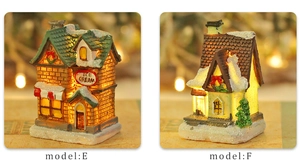 Close-up of lighted Christmas resin house models E and F with warm LED snowy textures