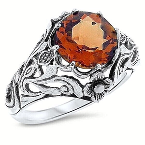 Antique silver floral ring featuring a large amber gemstone in a vintage vine design