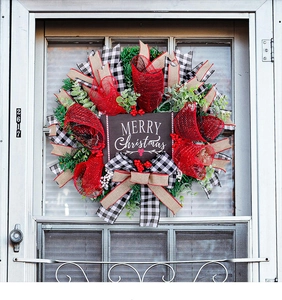Detail of Christmas wreath with plaid ribbons, red berries and Merry Christmas sign