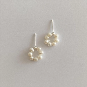Detail of round pearl hoop earrings with small white pearls and silver needles