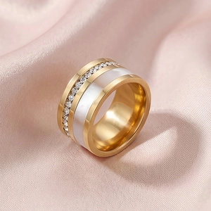 Anello dorato con fila di diamanti e intarsio in conchiglia bianca su seta rosa